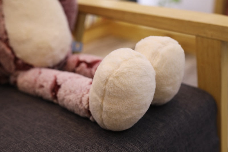 Trois peluches chats Kawaii alignées sur un canapé
