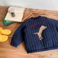Détail des broderies ludiques sur veste enfant, tigre et chien visibles
