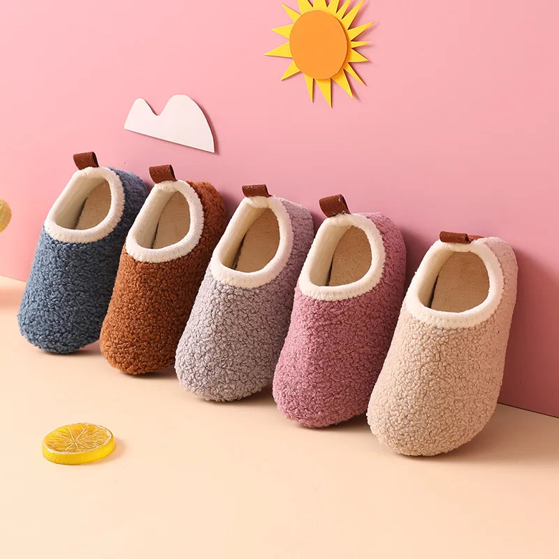 Chaussons enfants en laine avec semelle antidérapante sur sol en bois