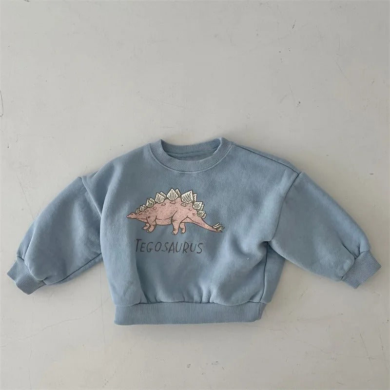 Enfant portant un sweat vert avec motif dinosaure