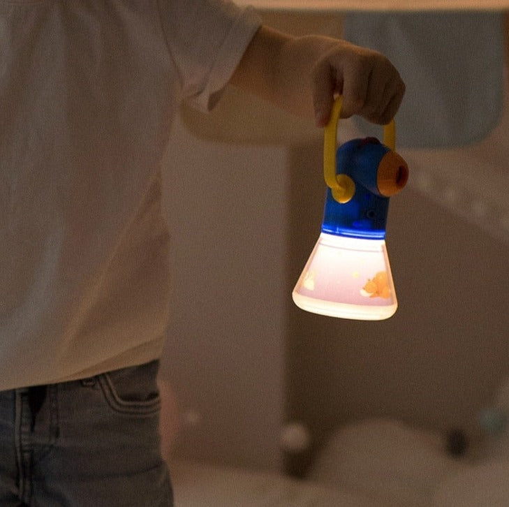 Enfant utilisant une lampe de poche pour projeter des contes