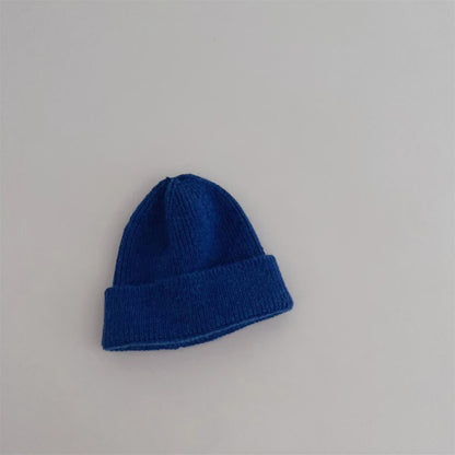 Bonnet jaune en coton posé sur une surface en bois