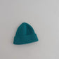 Bonnet bleu clair en coton, sur un fond texturé