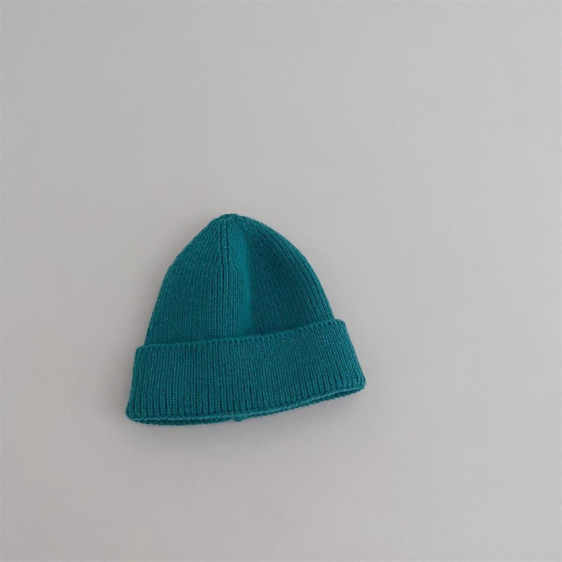 Bonnet bleu clair en coton, sur un fond texturé