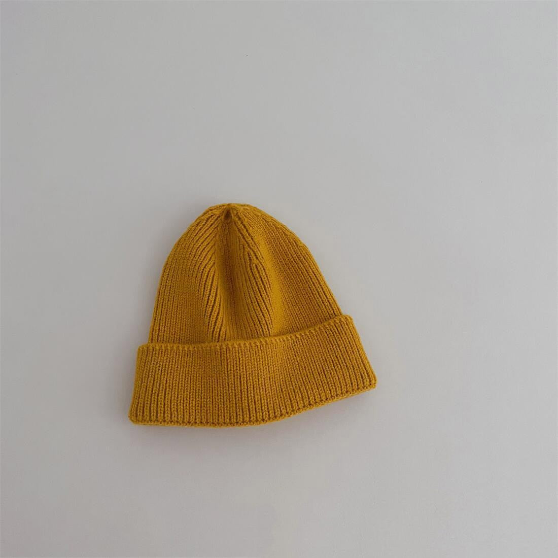Enfant souriant avec un bonnet caramel en coton