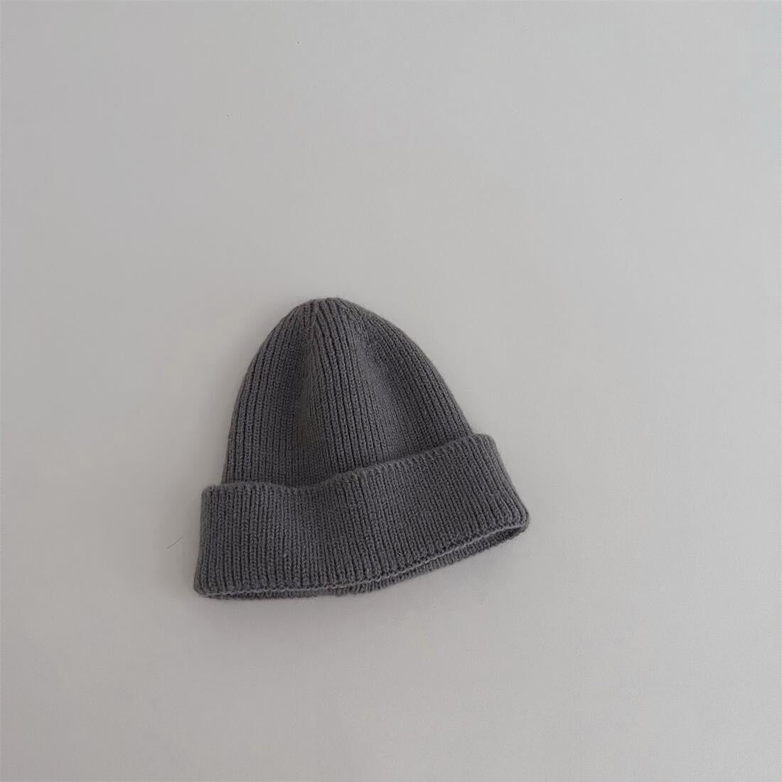 Bonnet bleu gris en coton, enroulé sur une table