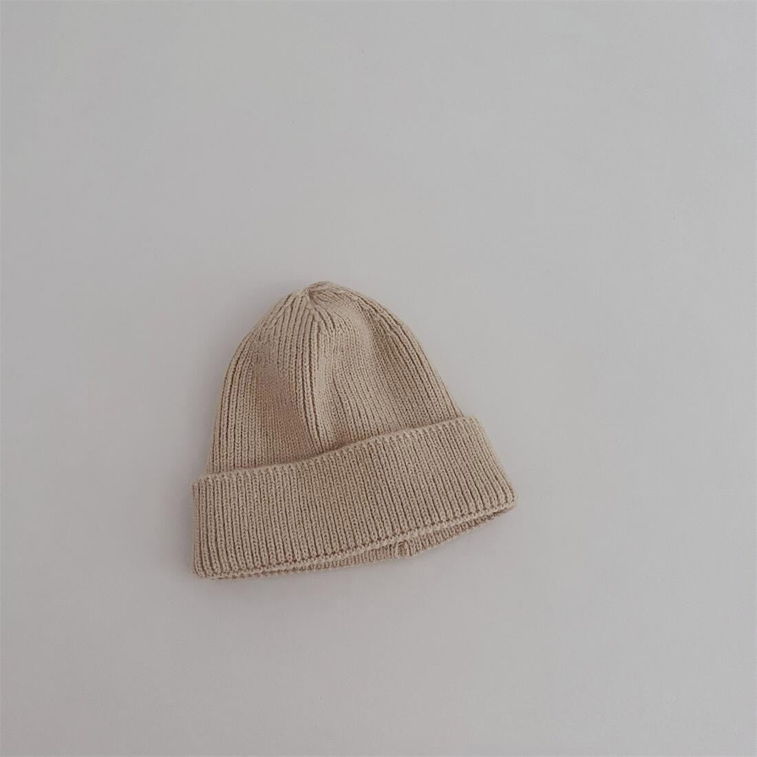 Enfant jouant avec un bonnet rouge en coton