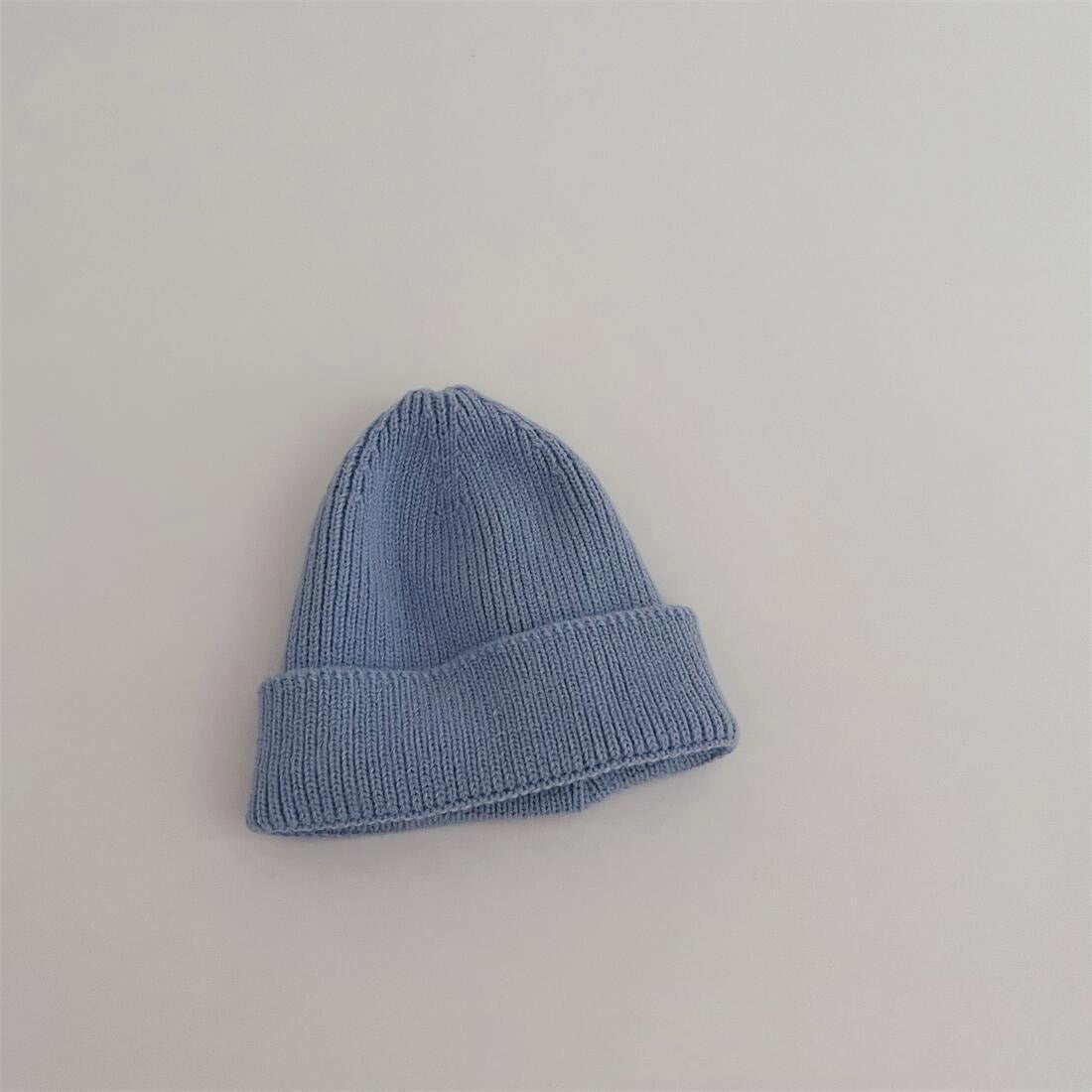 Enfant portant un bonnet vert en coton, souriant