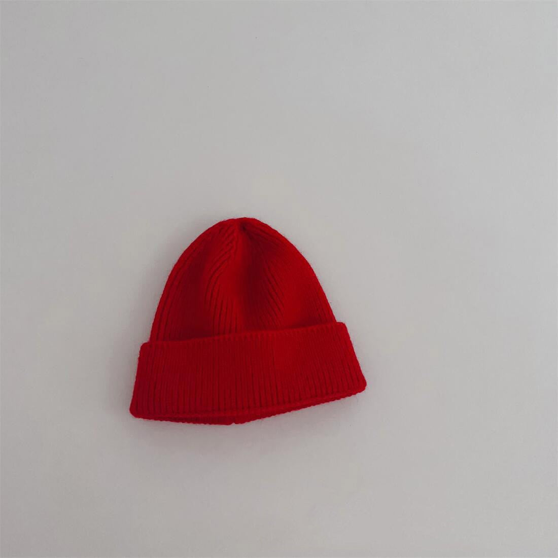 Enfant jouant dehors avec un bonnet orange en coton