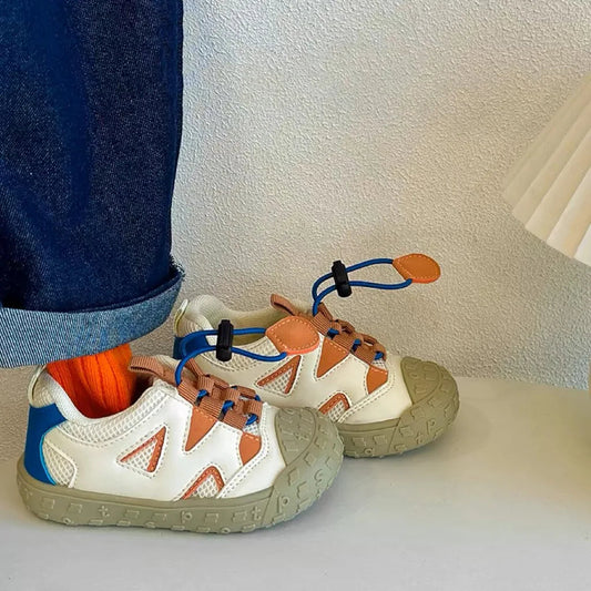 Baskets enfant posées sur une surface en bois clair