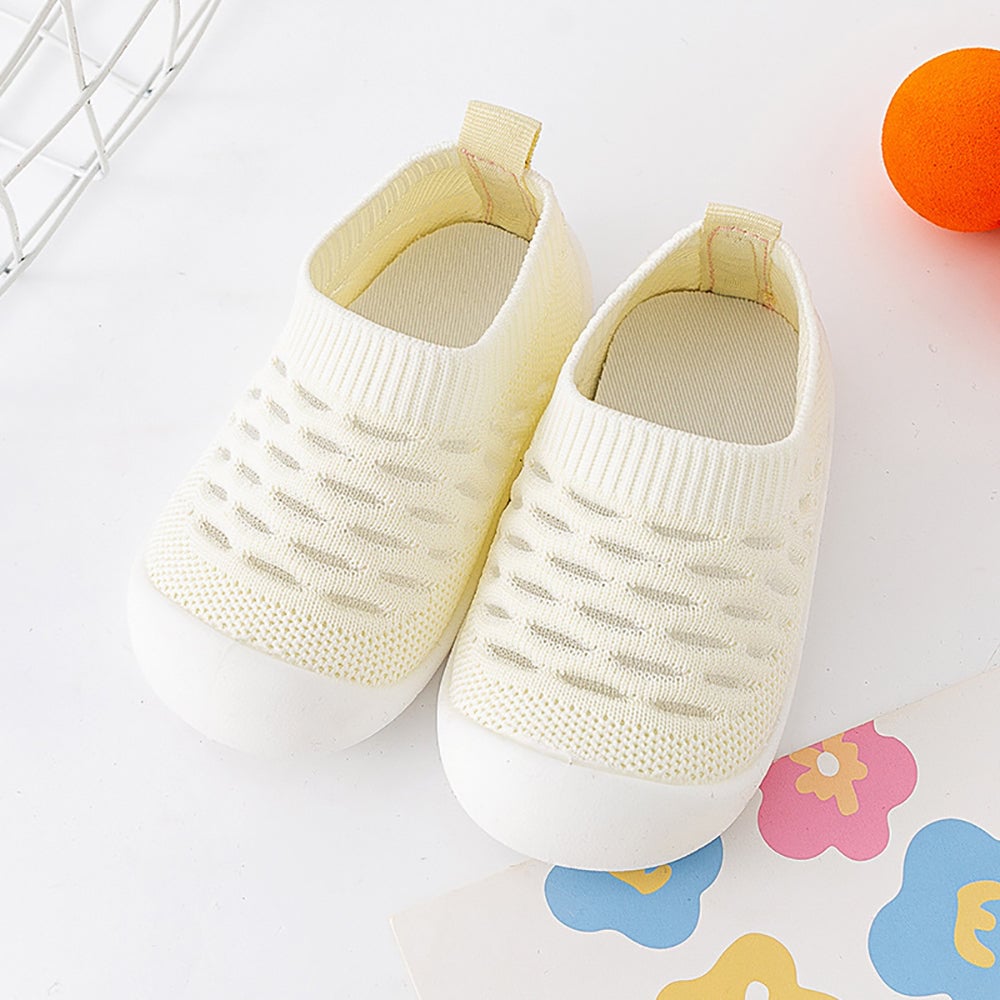 Baskets enfant multicolores posées sur un fond neutre