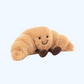 Croissant en peluche posé sur une surface claire