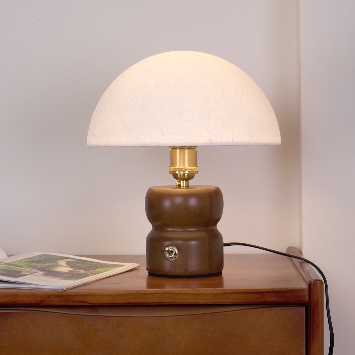 Lampe éteinte sur une commode, mettant en valeur son design compact