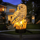 Lampe solaire hibou illuminant un jardin au crépuscule