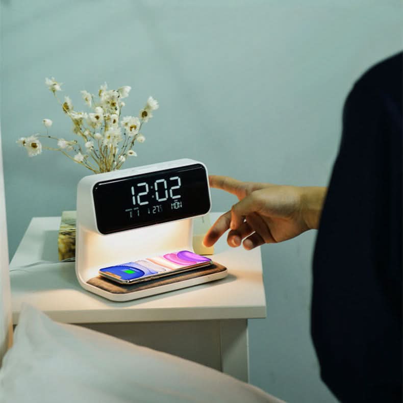 Réveil multifonctionnel sur une table de chevet blanche