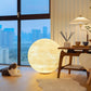 Lampe de sol lune posée près d'un fauteuil confortable