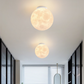 Lampe plafond design lune éclairant une salle à manger moderne