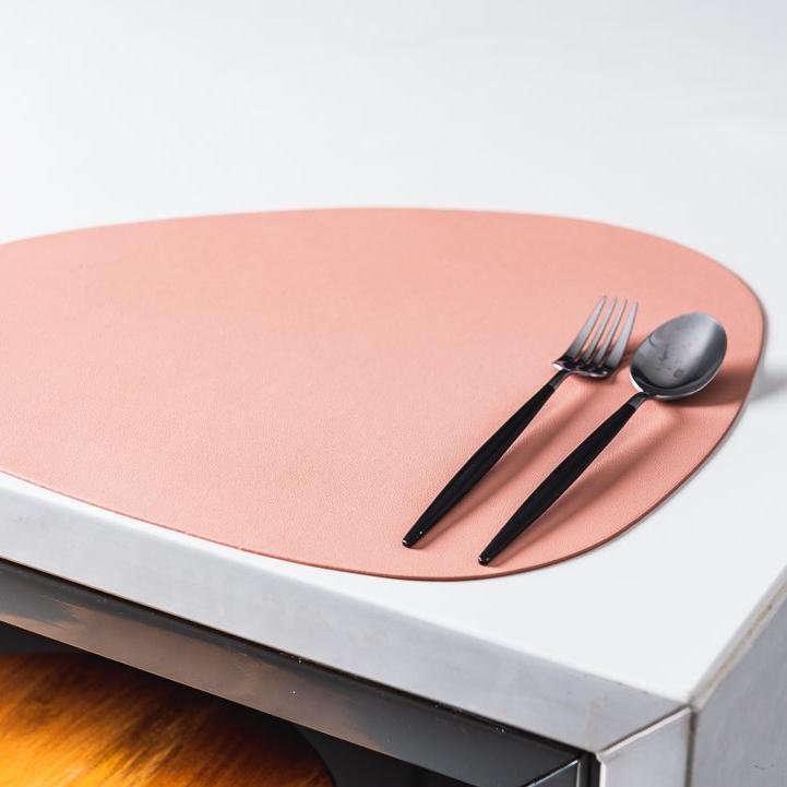 Sous-assiette en cuir sous une assiette blanche, vue latérale
