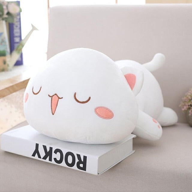 Chat en peluche kawaii posé sur une étagère