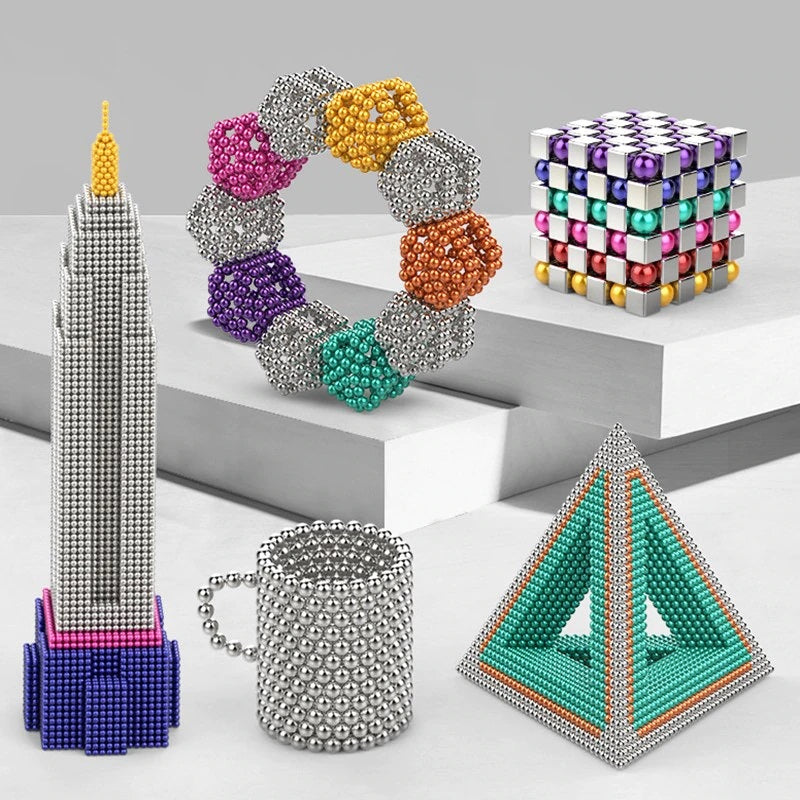 Enfant construisant une tour avec des boules magnétiques colorées