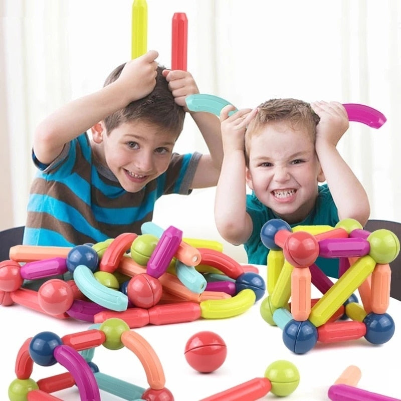 Enfant construisant une tour avec des blocs magnétiques colorés