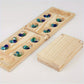 Plateau de jeu Mancala en bois ouvert avec jetons colorés