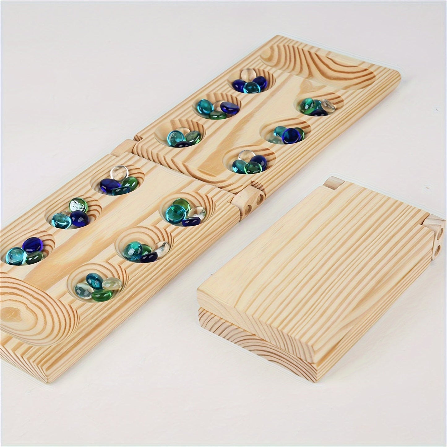 Plateau de jeu Mancala en bois ouvert avec jetons colorés