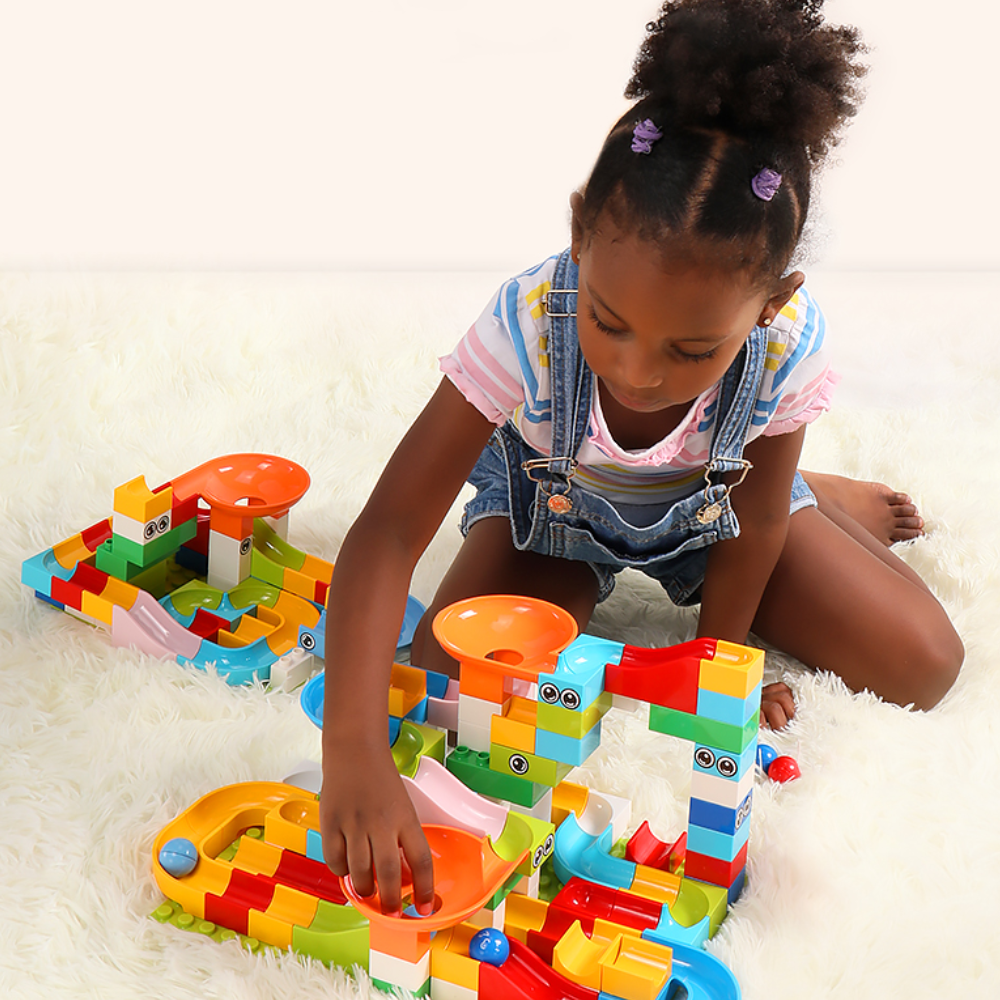 Enfant jouant avec une piste de billes modulaire