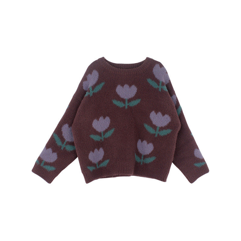Enfant portant un pull tulipes, sourire, extérieur ensoleillé