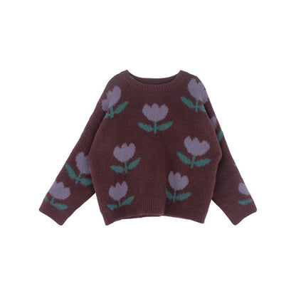 Enfant portant un pull tulipes, sourire, extérieur ensoleillé