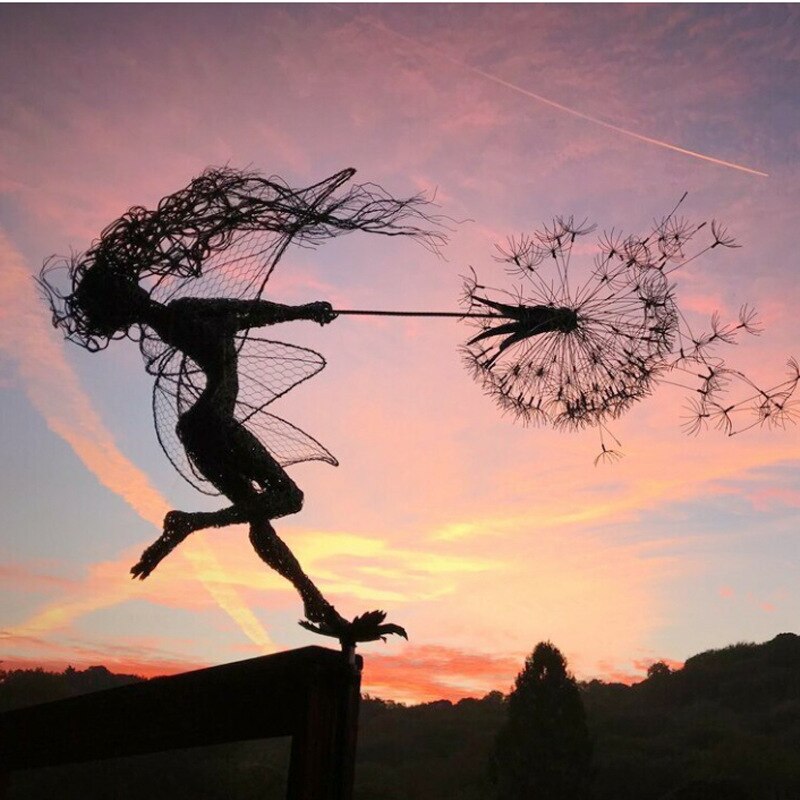 Silhouette gracieuse d'une fée en métal sur fond de ciel