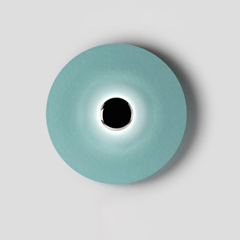 Détail de l'applique murale en métal bleu et lumière blanche