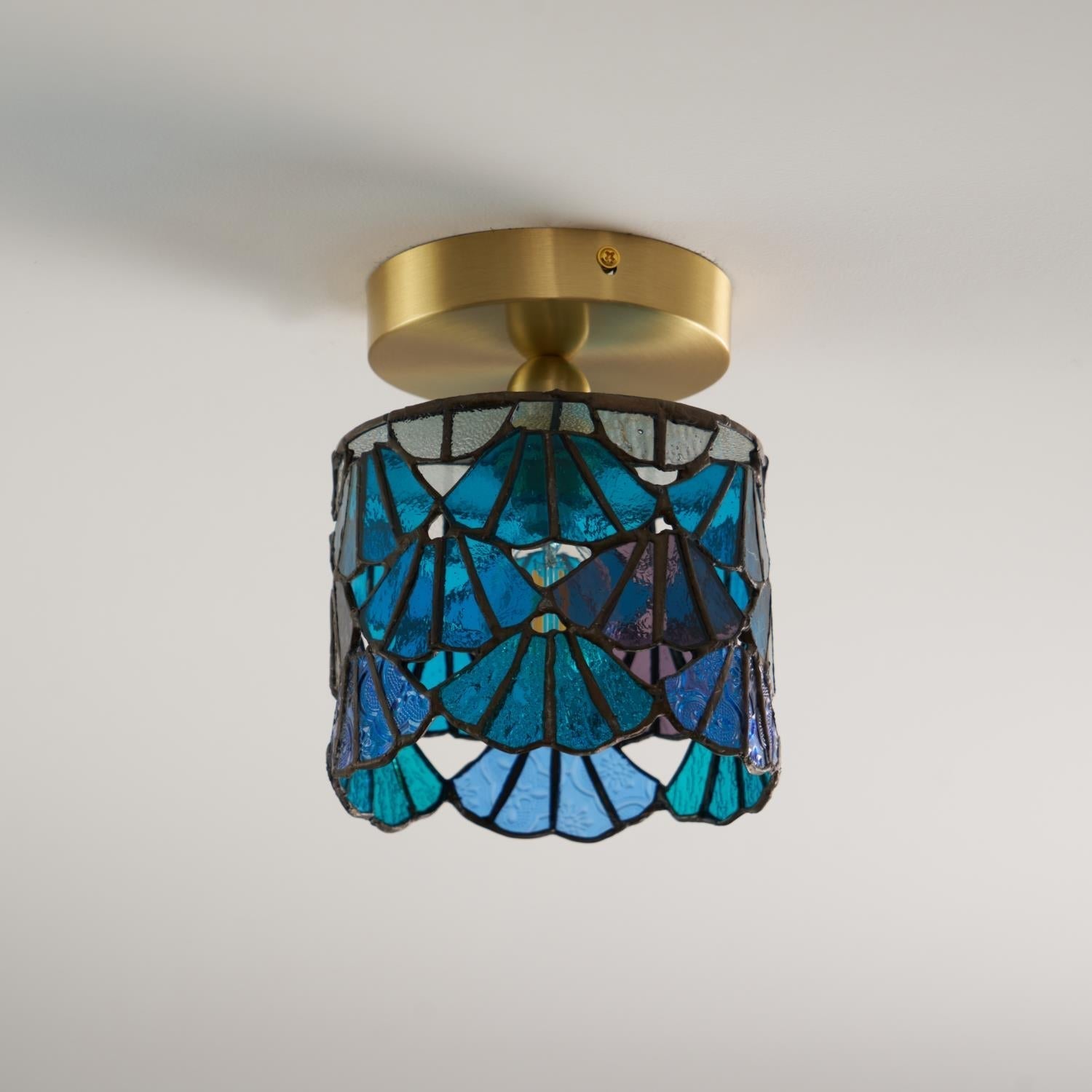 Mosaïque en verre bleu et rose éclairée de la lampe