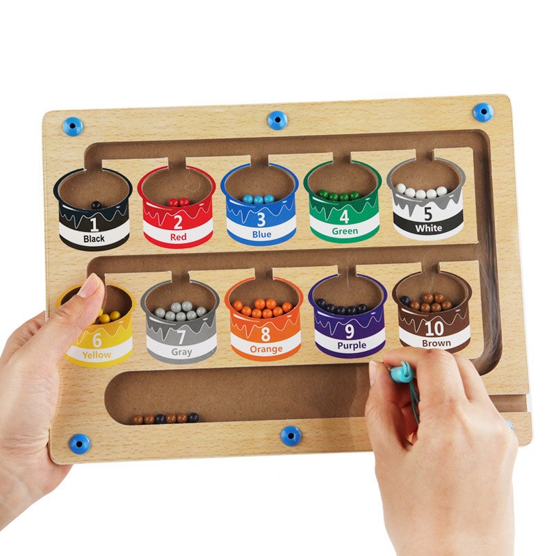 Enfant jouant avec un tableau de tri magnétique en bois coloré