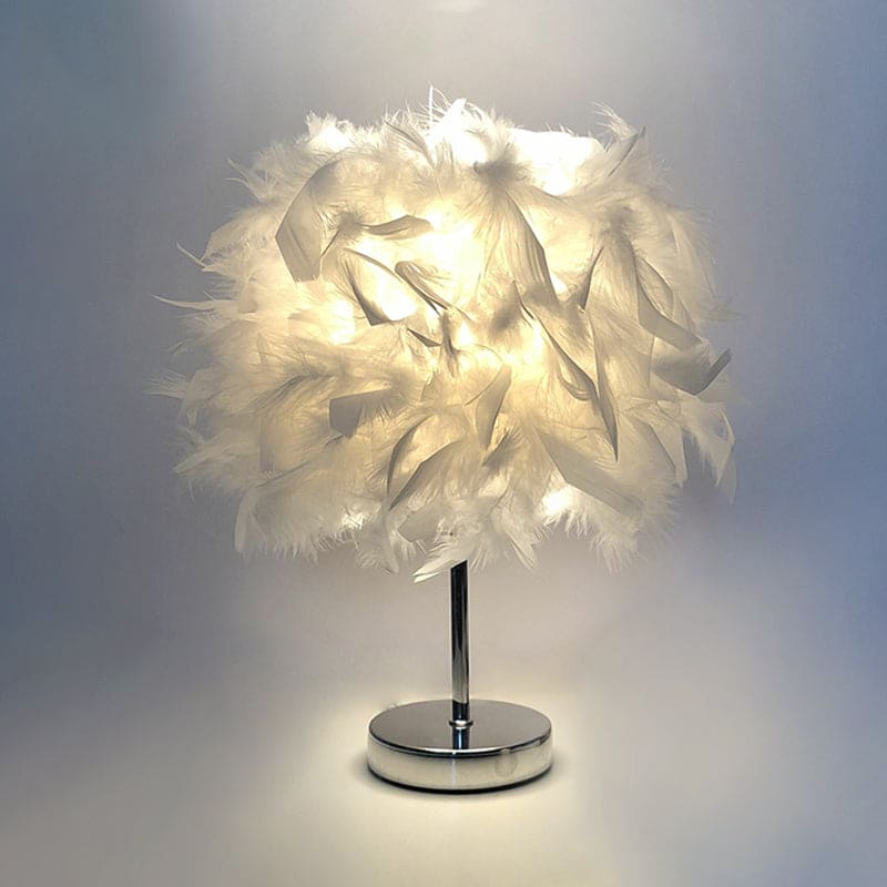 Lampe globe en plumes sur une table en bois