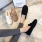 Chaussons en peluche crème sur un sol en bois