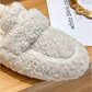 Chaussons kaki en peluche posés sur un tapis moelleux