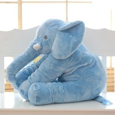 Coussin éléphant en peluche posé sur un lit d'enfant