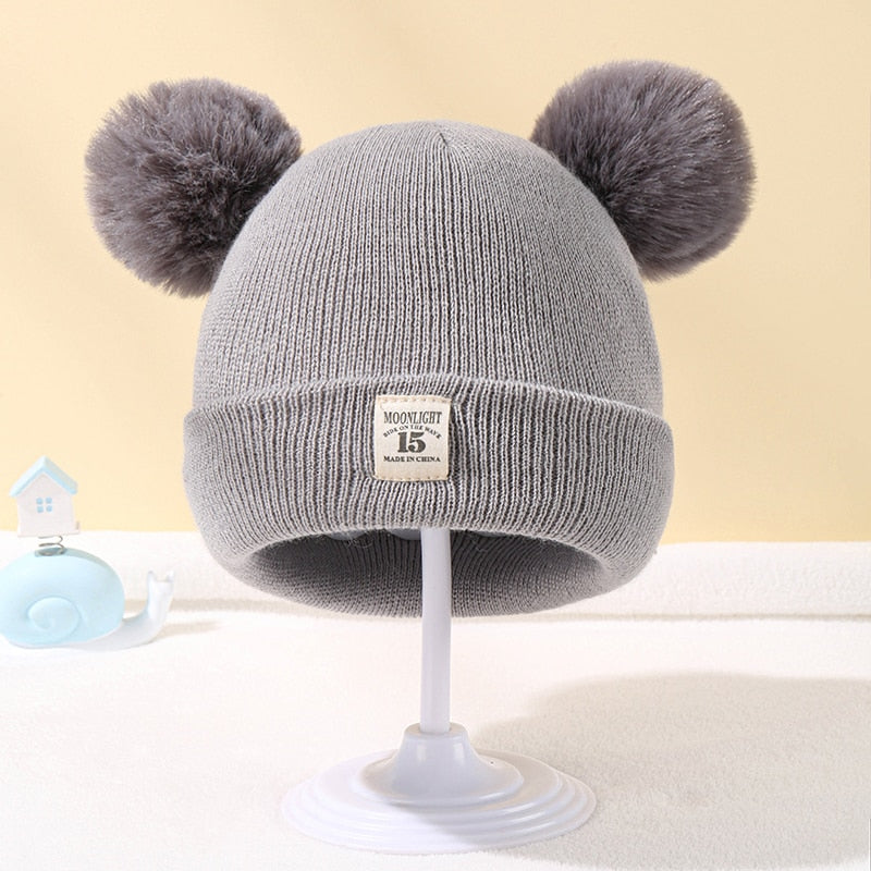 Enfant jouant dehors avec bonnet et pompon