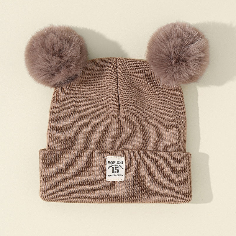 Enfant portant un bonnet chaud avec pompon en extérieur
