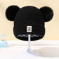 Vue latérale d'un bonnet enfant avec pompon multicolore