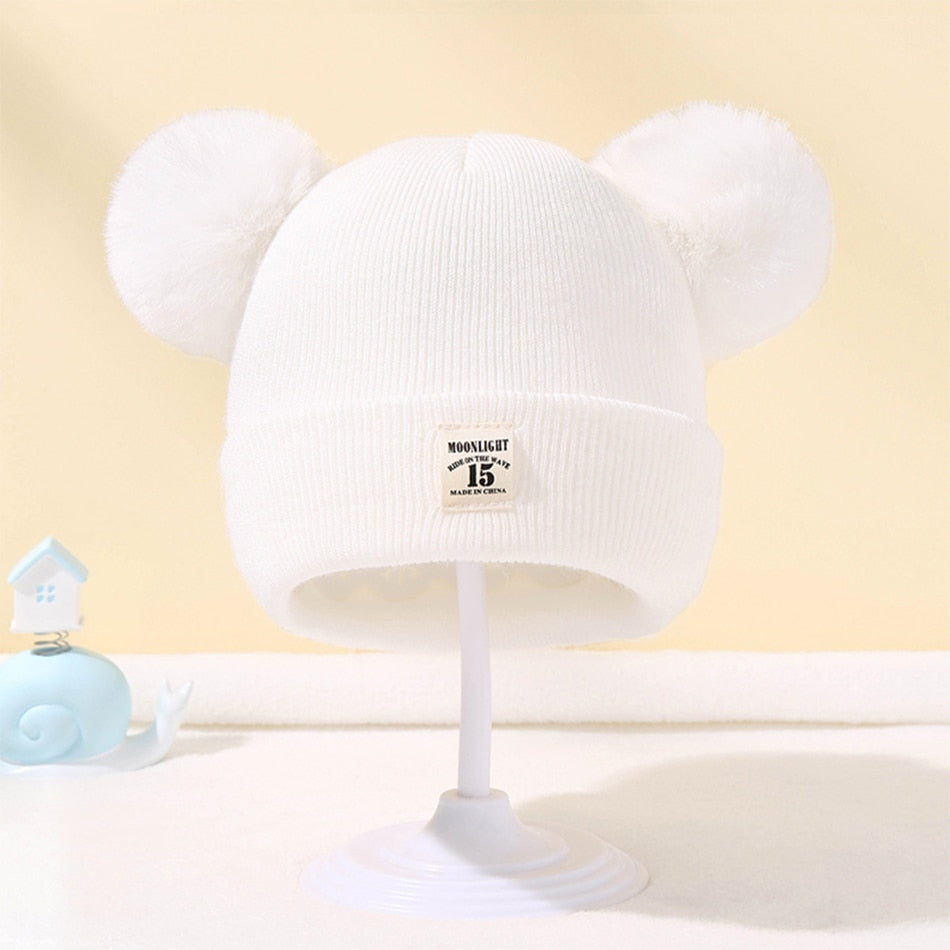 Bonnet enfant avec pompon sur fond neutre