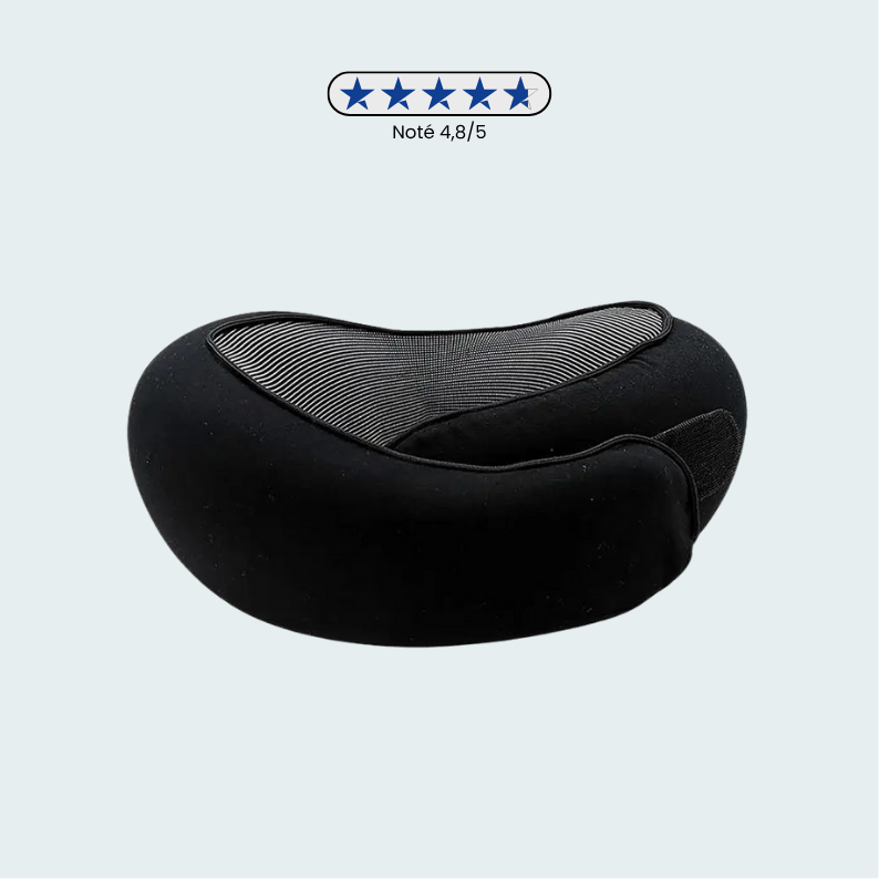 Coussin de voyage noir posé sur une surface en bois clair
