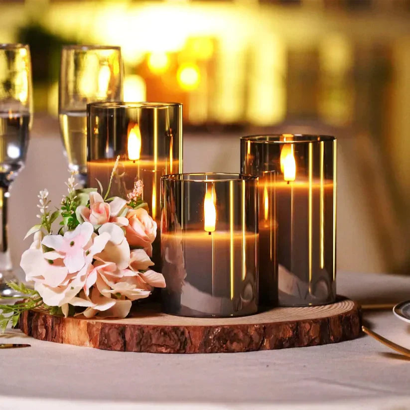 Trois bougies LED allumées sur une table en bois