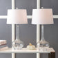 Lampe en céramique sur une étagère avec livres et plantes