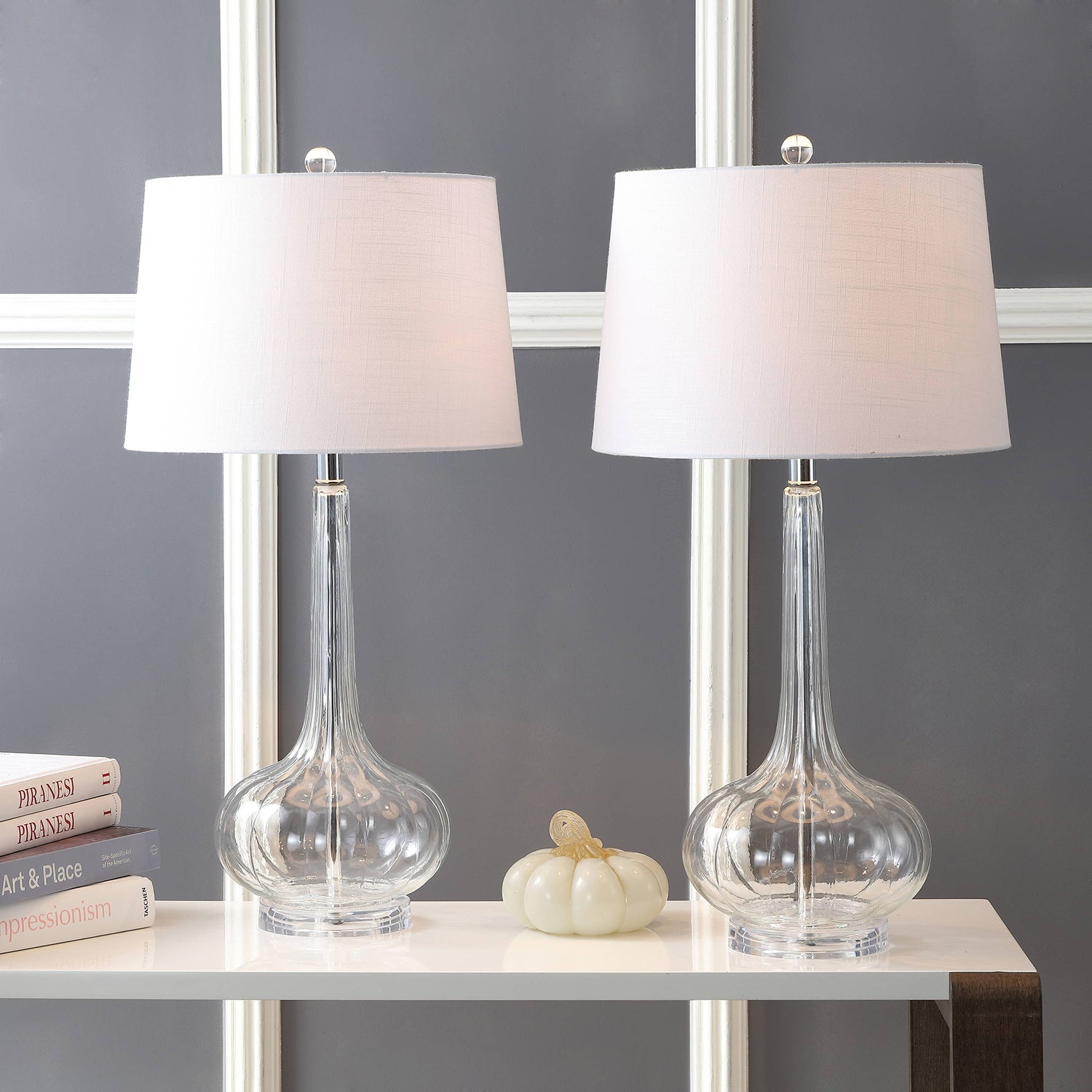 Lampe en céramique sur une étagère avec livres et plantes