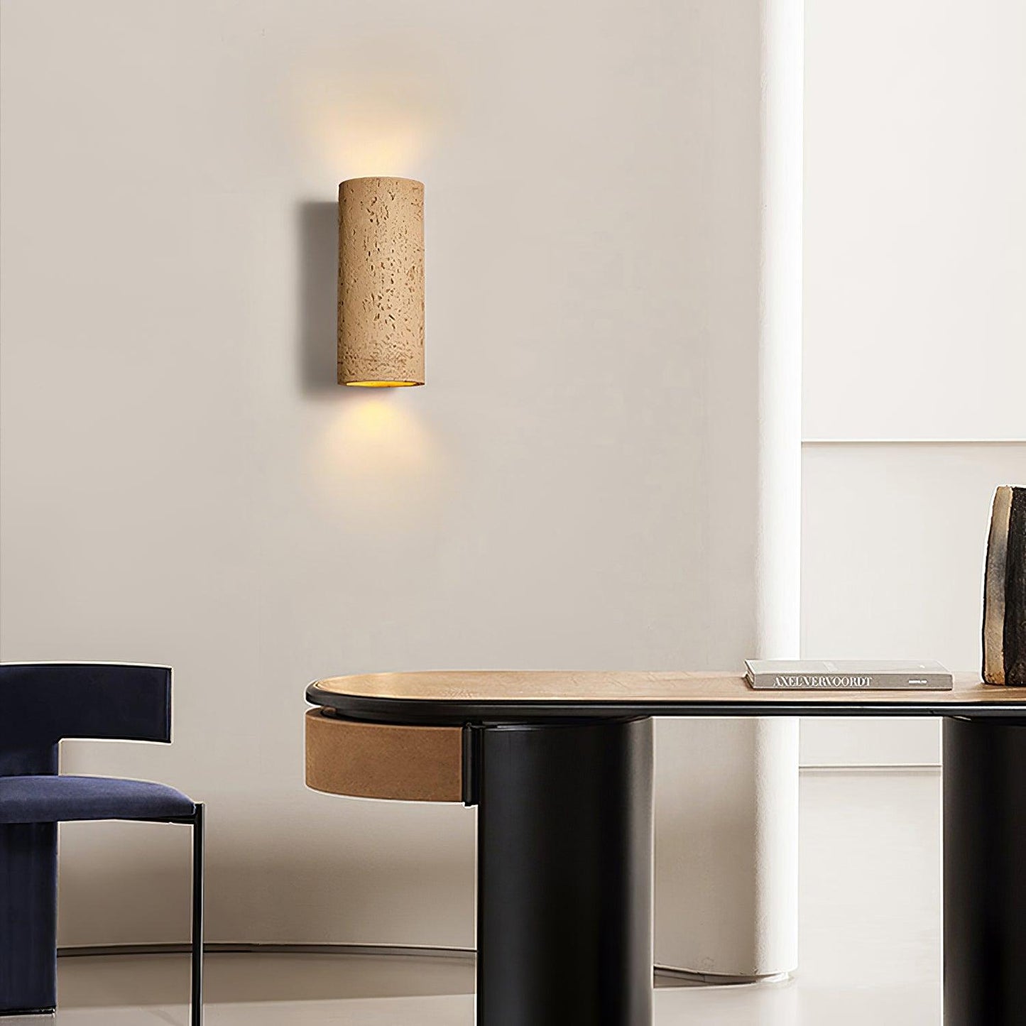 Applique noire projetant une lumière douce sur le mur