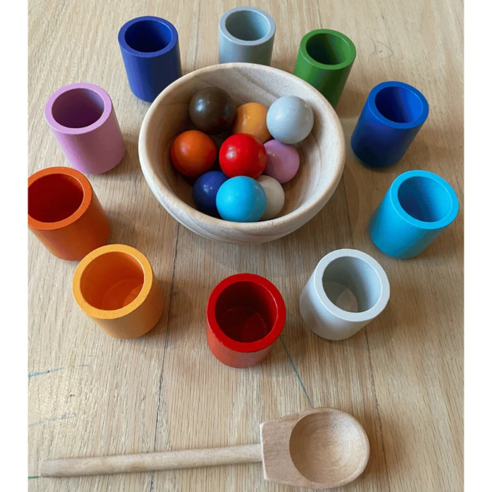 Enfant triant des balles colorées avec une cuillère