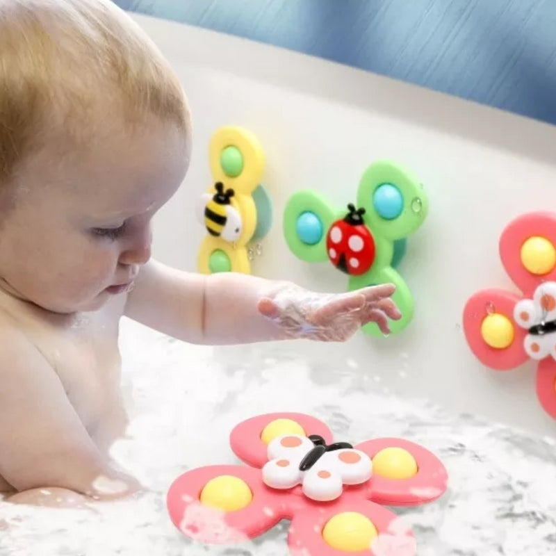 Enfant jouant avec jouet de bain rotatif sur mur