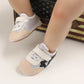 Chaussures bébé marron avec semelle antidérapante sur fond blanc
